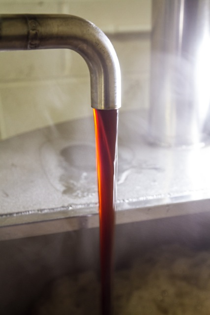 Cardiff, United Kingdom, November 26 2015. Beer pours into a vat at the Crafty Devil Brewery's microbrewery site.